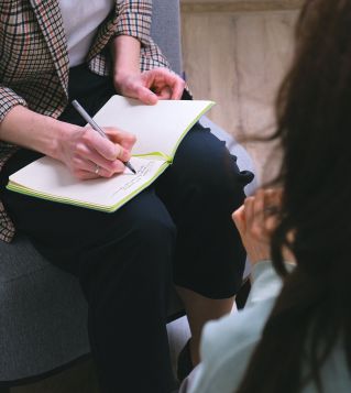 Crop counselor writing in diary while talking to patient